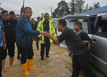 AHMAD Zahid Hamidi beramah mesra dengan penduduk yang terlibat banjir di Kampung Nangka, Besut, hari ini. - UTUSAN/PUQTRA HAIRRY ROSLI