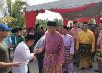 SAARANI Mohamad (tengah) dan Ahmad Zahid Hamidi (depan) bersalam dengan tetamu pada sambutan  Aidilftri di Kompleks UMNO Bagan Datuk, Perak, hari ini. - UTUSAN/AIN SAFRE BIDIN