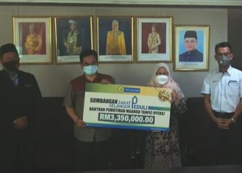 KHADIJAH Mohd. Khambali @ Hambali (dua dari kanan) menyerahkan plakad sebagai simbolik pemberian bantuan Zakat Selangor Peduli kepada Mohd. Shahzihan Ahmad dalam  Program Pemutihan Maahad Tahfiz Selangor di Bangunan Sultan Idris Shah di Shah Alam, Selangor.