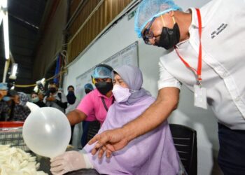 ZURAIDA Kamaruddin turut mencuba proses pembuatan sarung tangan getah ketika mengadakan lawatan ke kilang Meditech Gloves Sdn. Bhd di Nilai, Seremban, semalam.-UTUSAN/MOHD. SHAHJEHAN MAAMIN